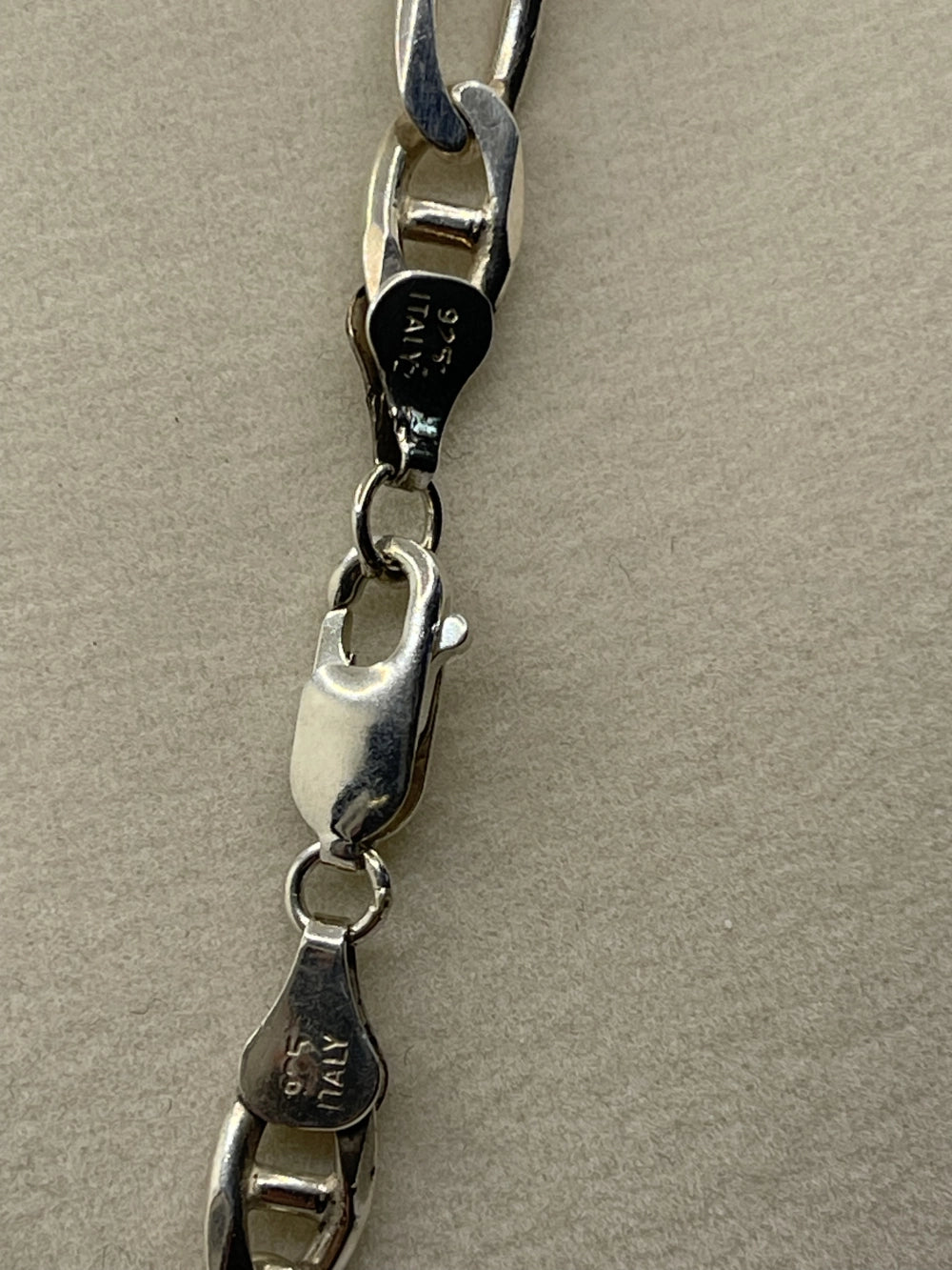 Closeup of the clasp of a Vintage AZ Italy Sterling Silver Figaro Chain Link Necklace 17"