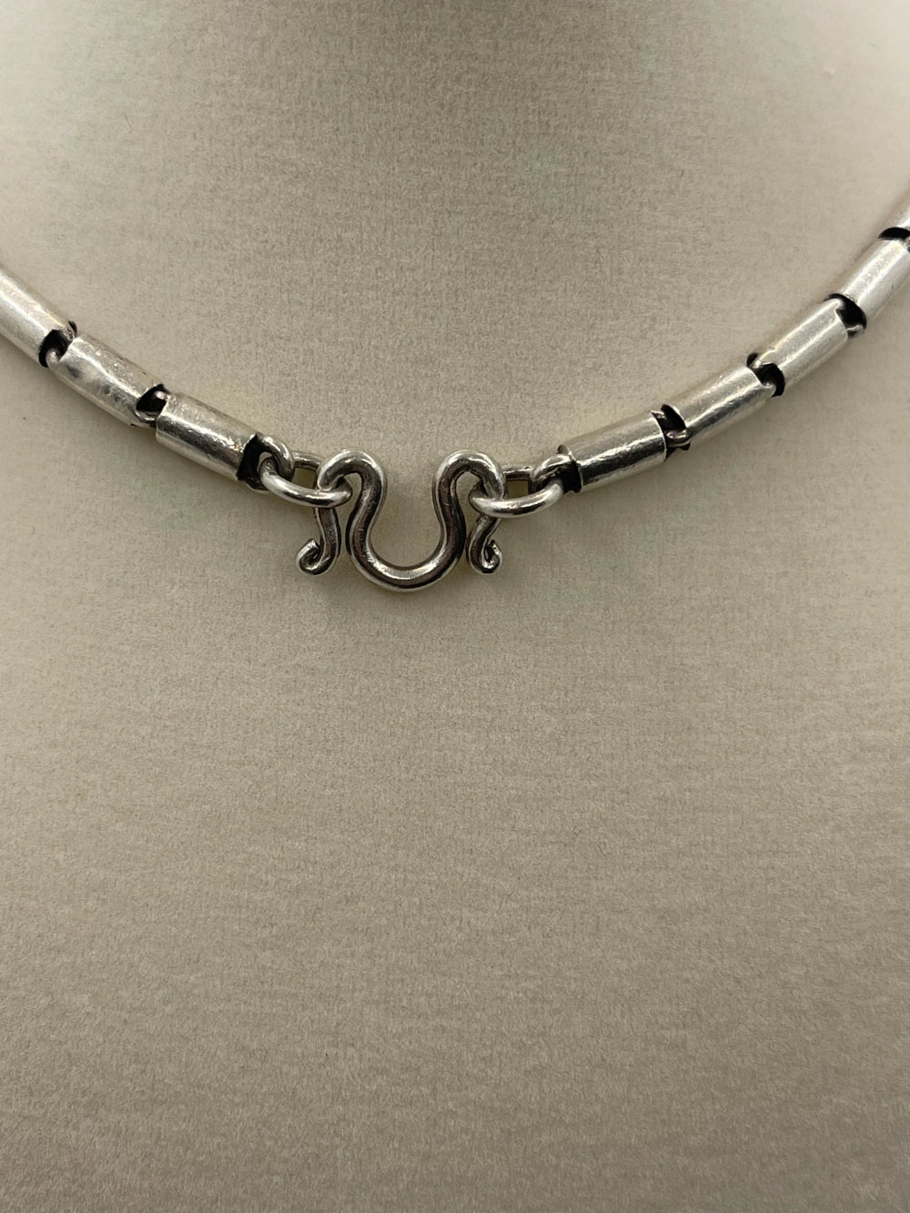 Closeup of the clasp of a Vintage Southwestern Modernist Bench-Made Sterling Silver Linked Tube Chain Necklace