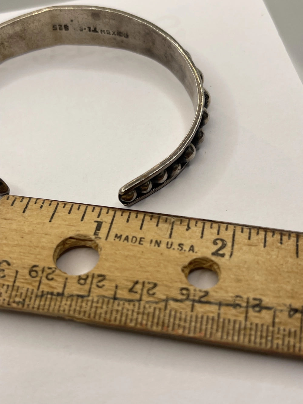 Vintage Anthony Pineda 970 Sterling Silver Modernist Cuff Bracelet next to closeup of ruler