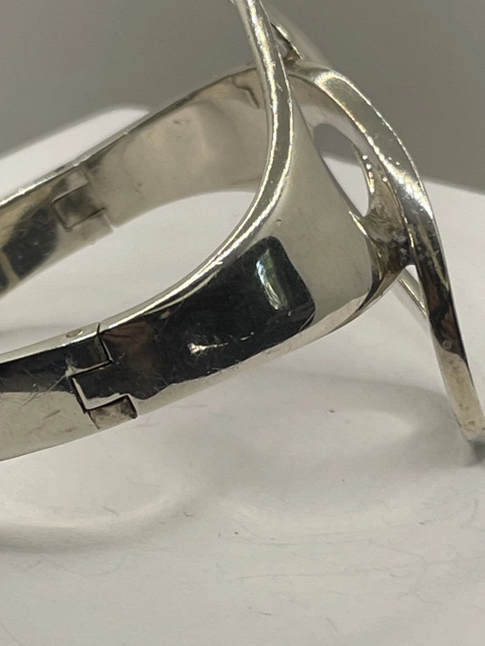 Closeup of the left side of Vintage Genuine Alicia de la Paz Modernist Interlocking Silver Bangle Bracelet