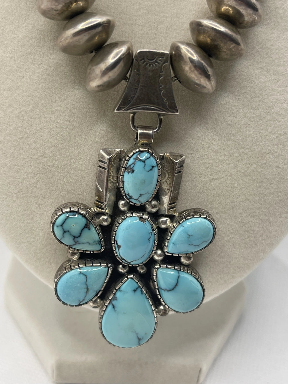 Closeup of floral penfant from the Vintage Tom Willeto Signed Turquoise Cluster Cross Necklace